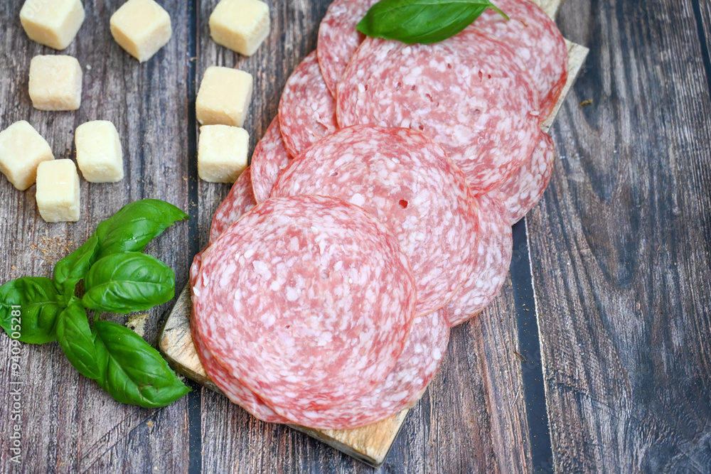 Slices Of  Traditional Italian antipasti salame Milano, parmesan cheese   on a wooden  cutting board.