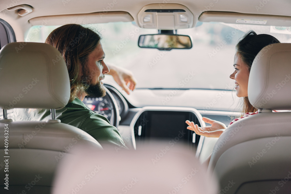 Young couple having a conversation inside a car, smiling and enjoying each other s company in a cozy atmosphere Young couple having a conversation inside a car, smiling and enjoying each other s company in a cozy atmosphere