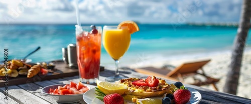 Delicious tropical breakfast with fruit and drinks by the ocean at a beachside resort in the morning sun Wide web banner.