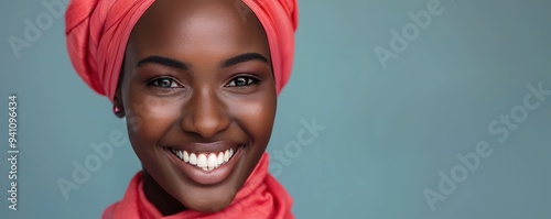 Portrait of a smiling woman wearing a vibrant orange hijab. photo