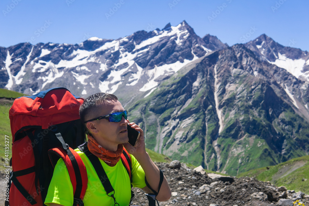 hiker with a backpack in the highlands talking on the phone hiker with a backpack in the highlands talking on the phone