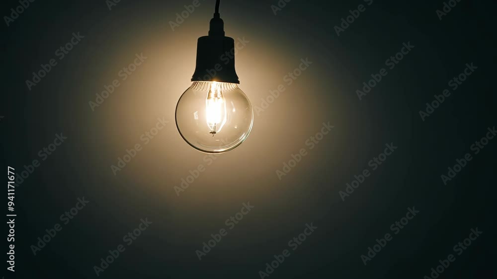 Bright light bulb illuminating a dark space creating a warm atmosphere at night Bright light bulb illuminating a dark space creating a warm atmosphere at night