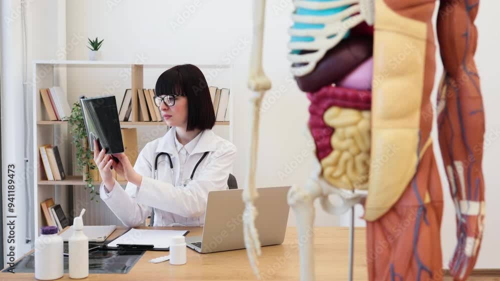 Female doctor analyzing X-ray in modern medical office. Medical ...