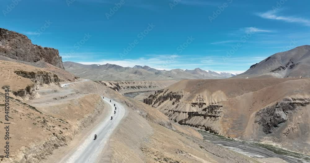 A convoy of motorcyclists weaves through the rugged terrain of the Himalayas, their engines roaring against a backdrop of towering peak, reveling in the high-altitude thrill of the journey. A convoy of motorcyclists weaves through the rugged terrain of the Himalayas, their engines roaring against a backdrop of towering peak, reveling in the high-altitude thrill of the journey.