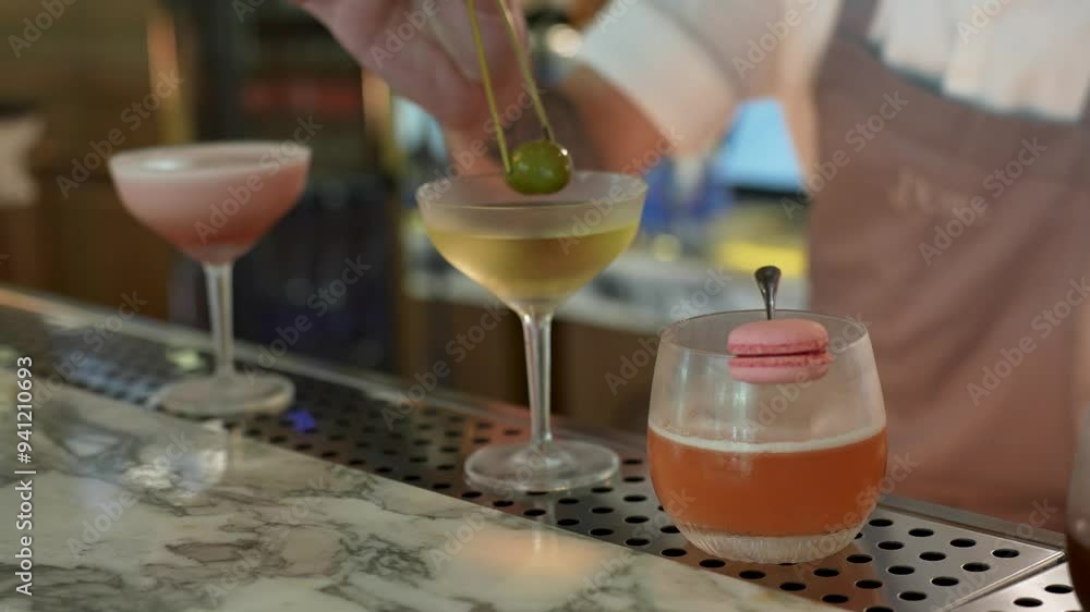 Barman making cocktail. Bartender is making cocktail at bar counter, close-up Barman making cocktail. Bartender is making cocktail at bar counter, close-up