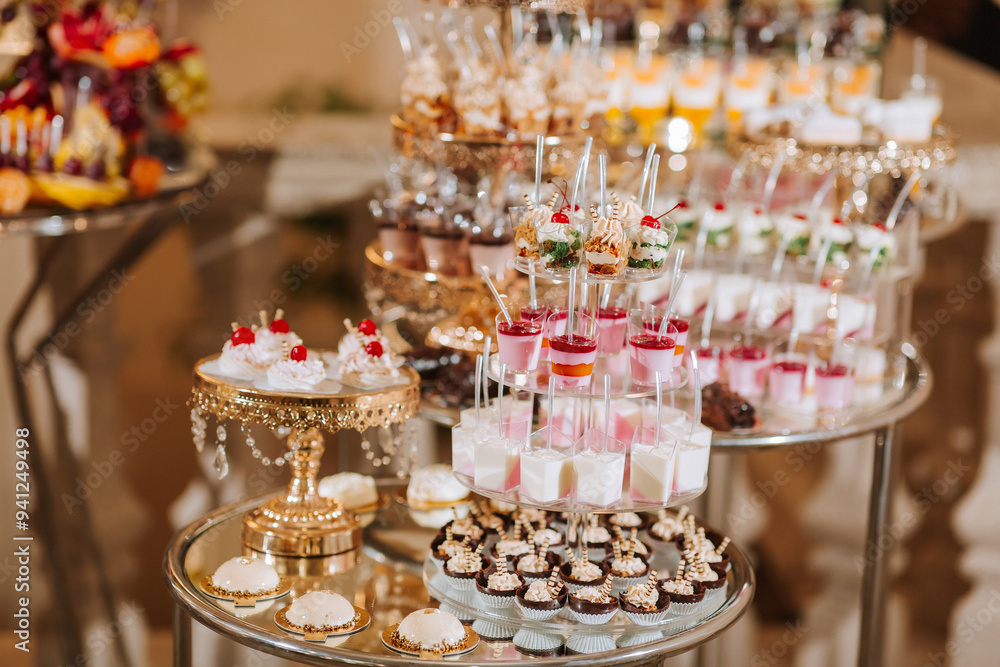 A table full of desserts and drinks with a fancy gold plated stand A table full of desserts and drinks with a fancy gold plated stand