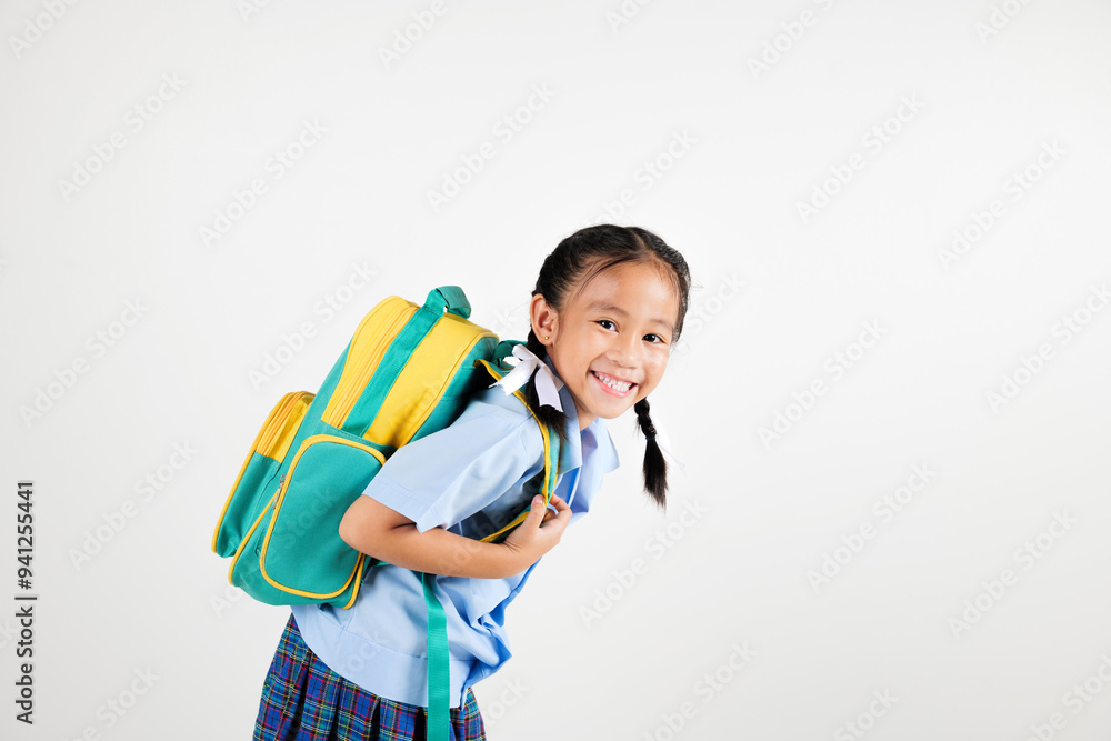 Portrait smile Asian little girl kindergarten holding a green and yellow backpack posing studio isolated white background, happy cute woman kid wear school uniform plaid skirt, back to school concept Portrait smile Asian little girl kindergarten holding a green and yellow backpack posing studio isolated white background, happy cute woman kid wear school uniform plaid skirt, back to school concept
