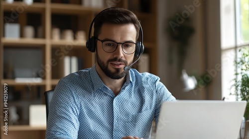  Customer Service Representative Working from Home Office, Engaged in Call with Headset, Viewing Computer Screen. Modern, Well-Lit Space with Glass Walls and Daylight.