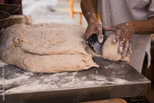 Male hands knead yeast dough for baking bread