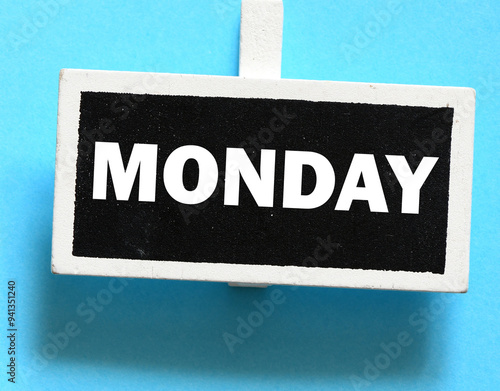 The word MONDAY on a small chalk board over a blue background. photo