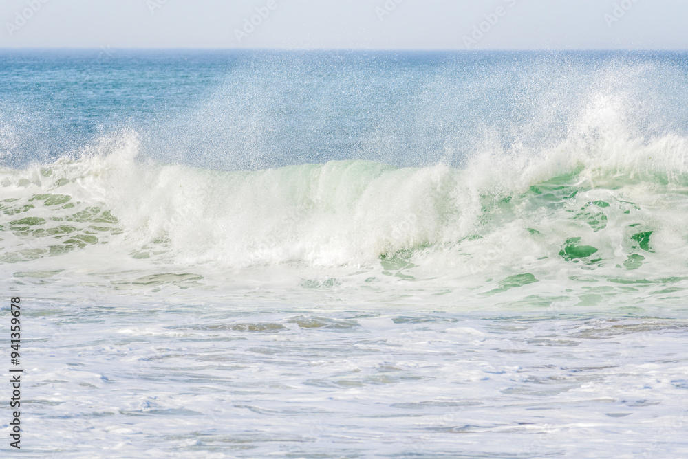 Big ocean wave breaking on the shore throwing up clouds of spray on a windy autumn day Big ocean wave breaking on the shore throwing up clouds of spray on a windy autumn day