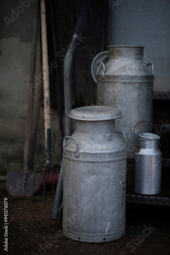 Different sizes of traditional milk churns on a Devon farm, UK.