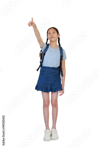 Smiling Asian girl child with backpack bag pointing index finger up empty space posture isolated on white background. Full length photo with clipping path.