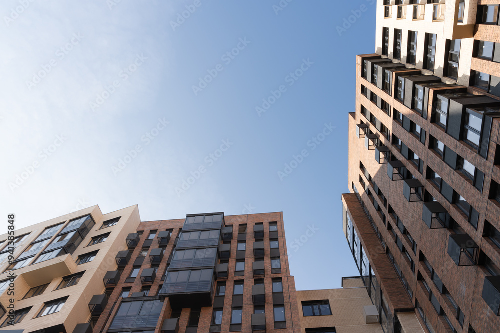 Fototapeta premium A low-angle view of modern apartment buildings against a clear blue sky.