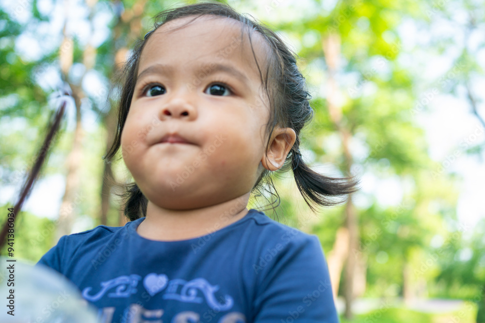 Portrait of happy asian toddler girl walking in city public tree park Portrait of happy asian toddler girl walking in city public tree park