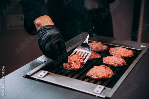 Obraz na płótnie Grilling meat patties for classic burger in a cafe of a restaurant. w salonie