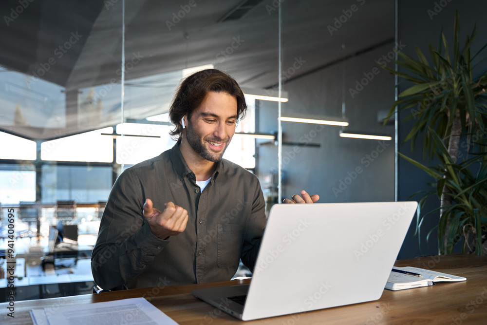 Happy business man in earbuds using laptop communicating on video call. Male hr manager professional executive in office looking at computer having conference online hybrid work meeting job interview. Happy business man in earbuds using laptop communicating on video call. Male hr manager professional executive in office looking at computer having conference online hybrid work meeting job interview.