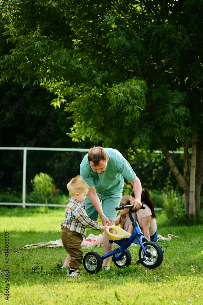 Happy Caucasian family on picnic having fun, eating and playing games on green grass Happy Caucasian family on picnic having fun, eating and playing games on green grass