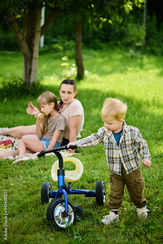 Happy Caucasian family on picnic having fun, eating and playing games on green grass