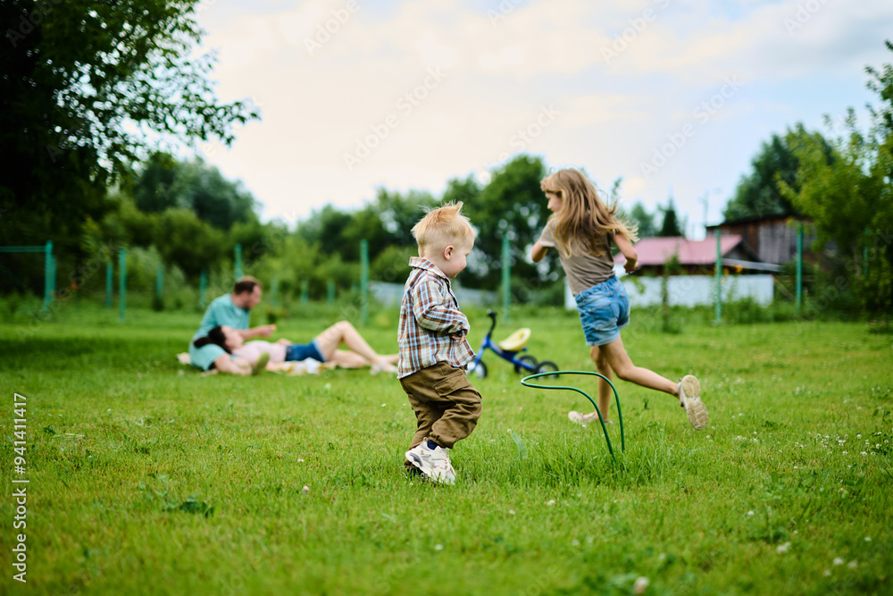 Happy Caucasian family on picnic having fun, eating and playing games on green grass Happy Caucasian family on picnic having fun, eating and playing games on green grass