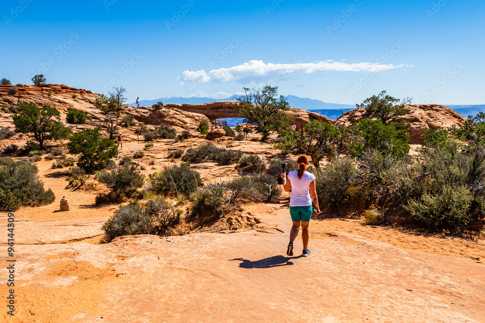 A girl hiking towards the Mesa Arch area of the Island in the Sky District of Canyonlands national park in Utah USA.