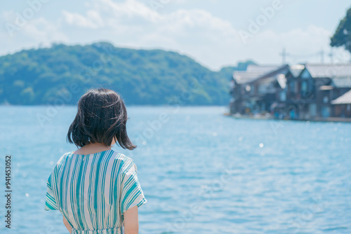 日本の美しい伊根湾と舟屋の景色を眺める女性