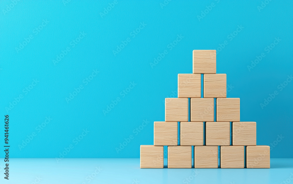 Wooden blocks pyramid on a blue background symbolizing structure, balance, and growth. Perfect for business, education, and growth concepts. Wooden blocks pyramid on a blue background symbolizing structure, balance, and growth. Perfect for business, education, and growth concepts.