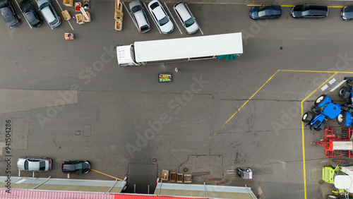 Drone photography of a forklift unloading cargo from a truck during summer day