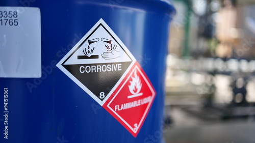 Foto Corrosive warning sign label and flammable liquid warning sign label on the barrel tank