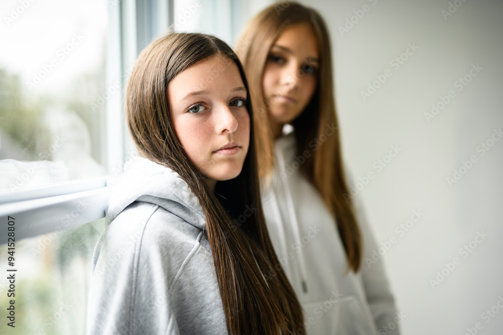 Two best girlfriends together on white studio wearing hoodies Two best girlfriends together on white studio wearing hoodies
