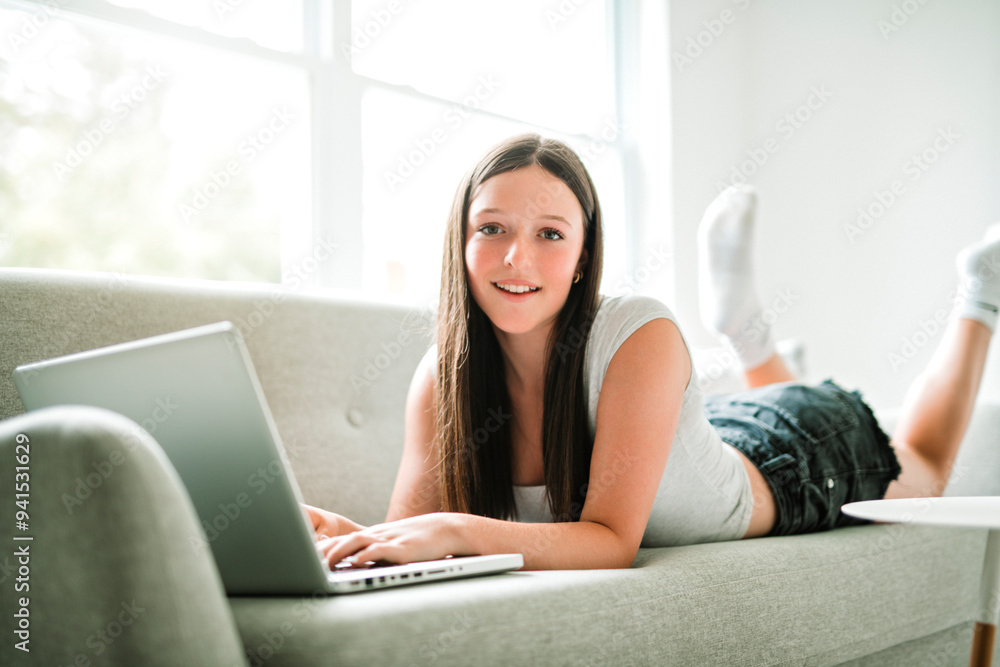 teen using laptop sit on sofa in the living room. teen using laptop sit on sofa in the living room.
