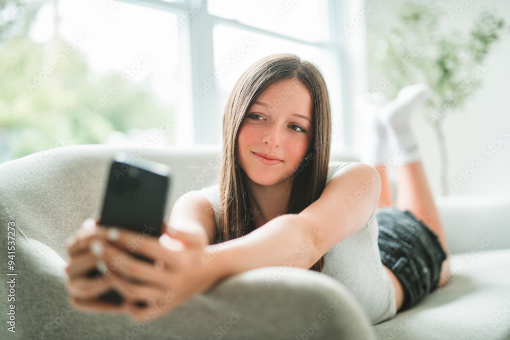 teen using cellphone lay on sofa in the living room. teen using cellphone lay on sofa in the living room.