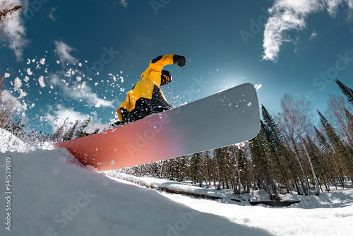 Obraz na płótnie Professional young snowboarder jumps from the kicker at the forest slope