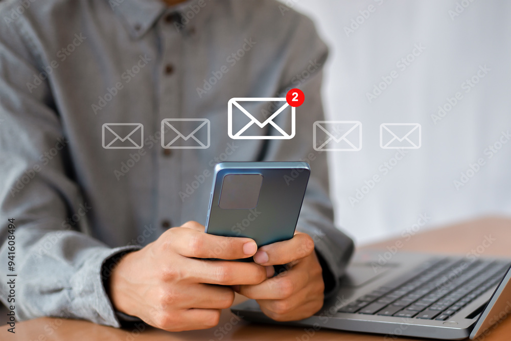 Man uses smartphone with icon notifying 2 new email messages. Communication business technology.