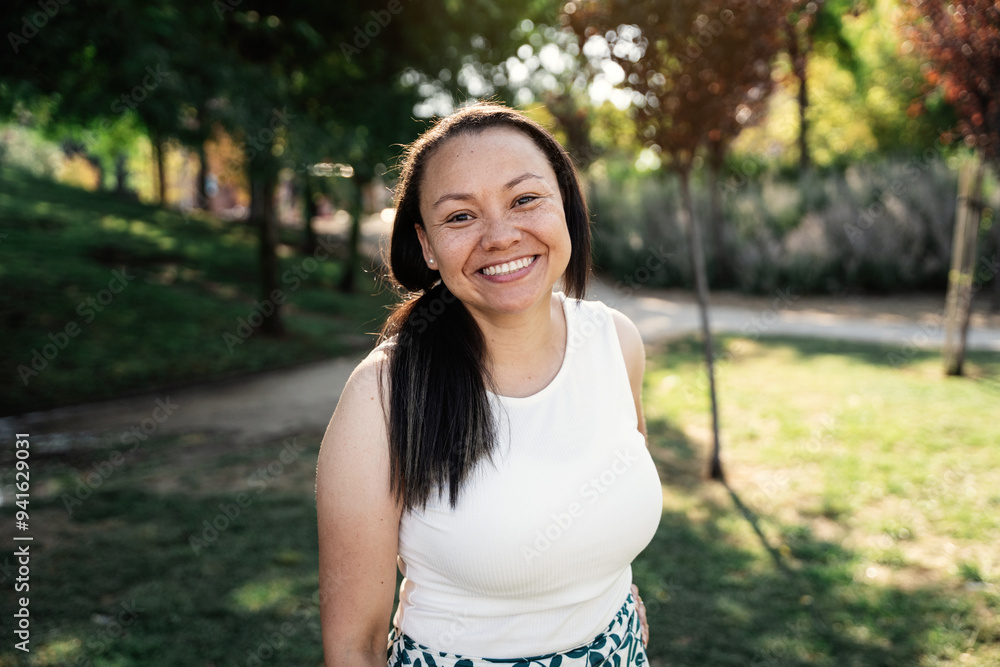 Portrait of smiling colombian woman enjoying a sunny day in a lush green park Portrait of smiling colombian woman enjoying a sunny day in a lush green park