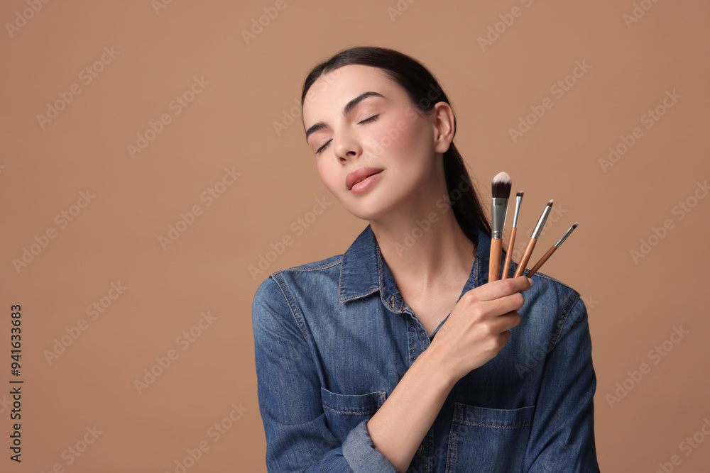 Obraz premium Beautiful makeup. Attractive woman with brushes on beige background, space for text