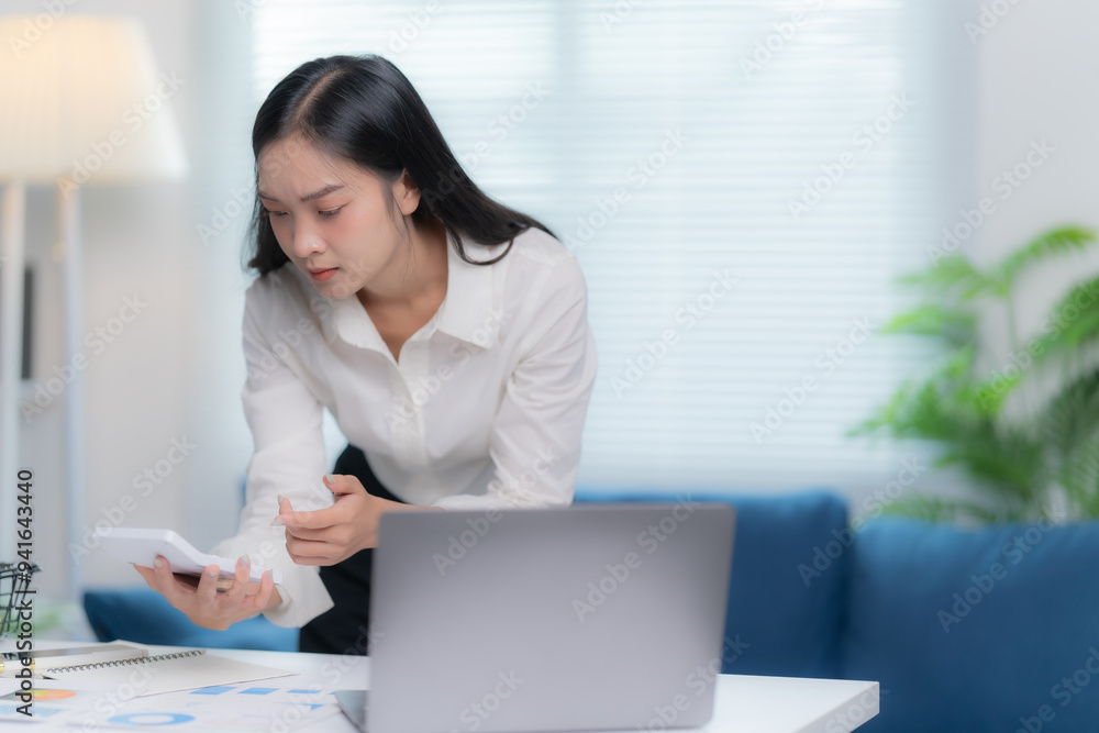 Asian businesswomen working in the office talking the phone, and checking the report Asian businesswomen working in the office talking the phone, and checking the report