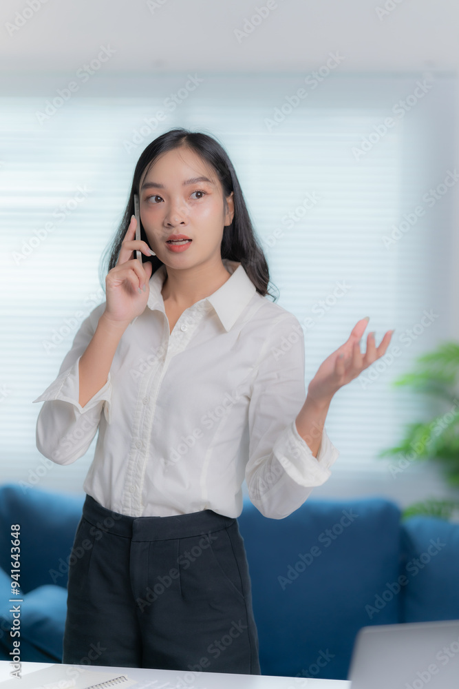 Asian businesswomen working in the office talking the phone, and checking the report Asian businesswomen working in the office talking the phone, and checking the report