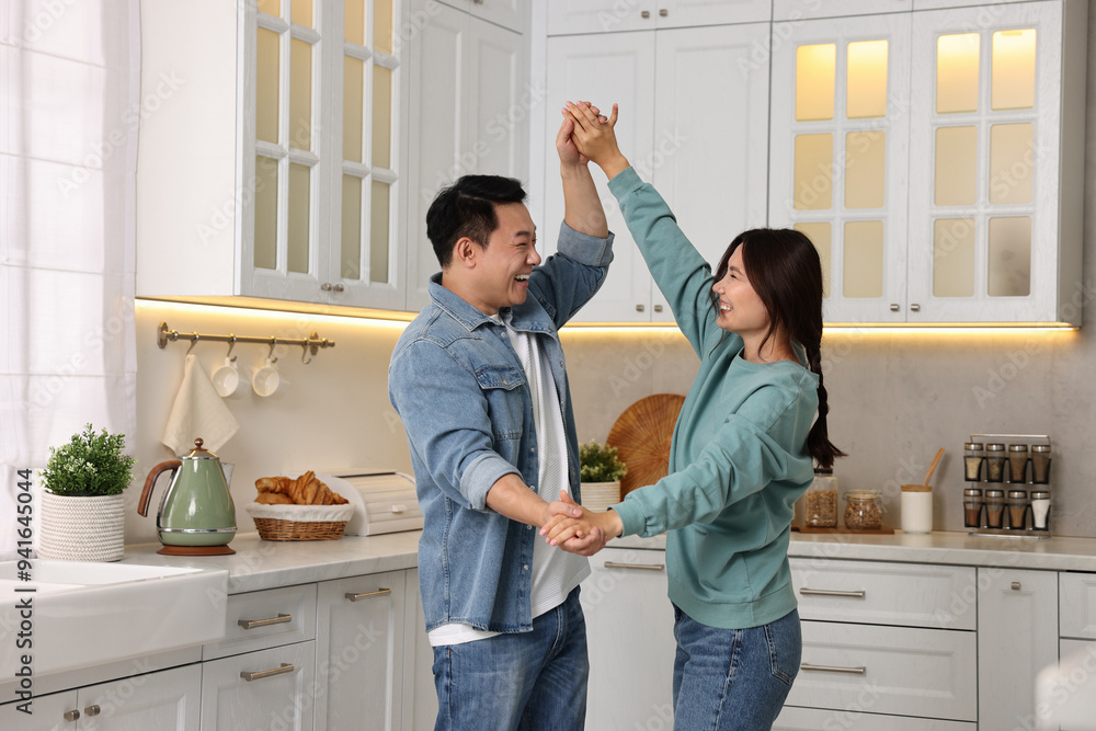 Happy lovely couple dancing together in kitchen Happy lovely couple dancing together in kitchen