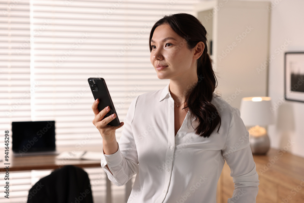 Portrait of beautiful businesswoman with smartphone in office Portrait of beautiful businesswoman with smartphone in office