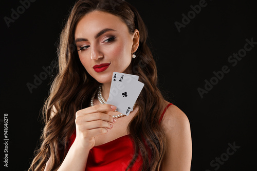 Poker game. Charming woman with playing cards on black background