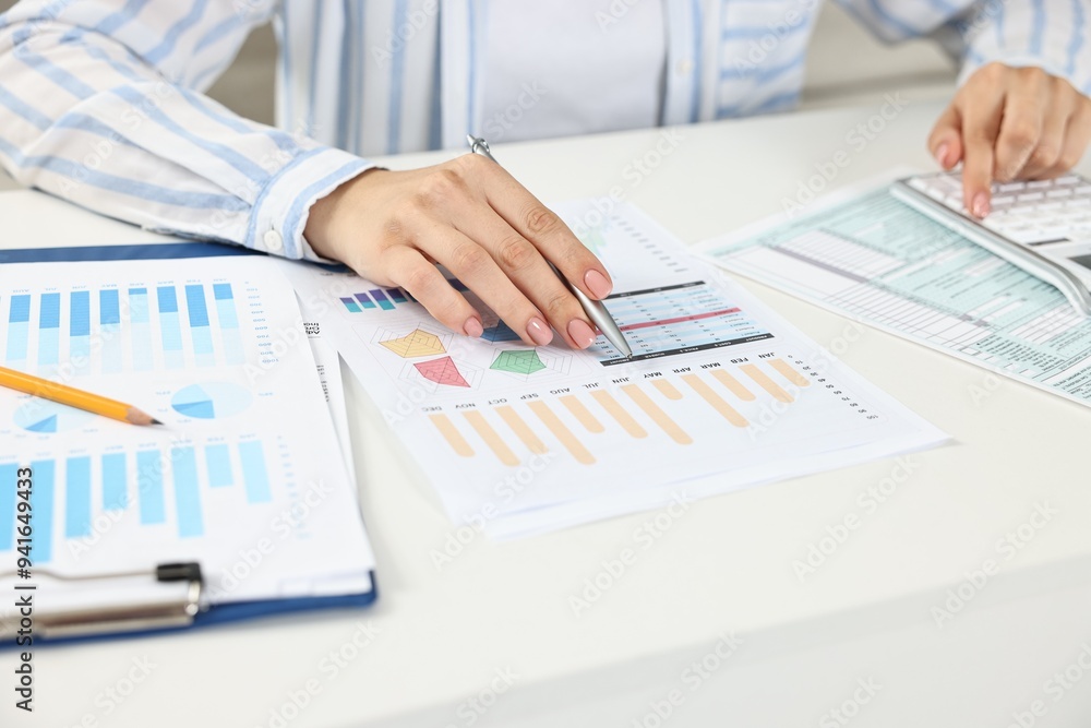 Budget planning. Woman with papers using calculator at white table, closeup Budget planning. Woman with papers using calculator at white table, closeup