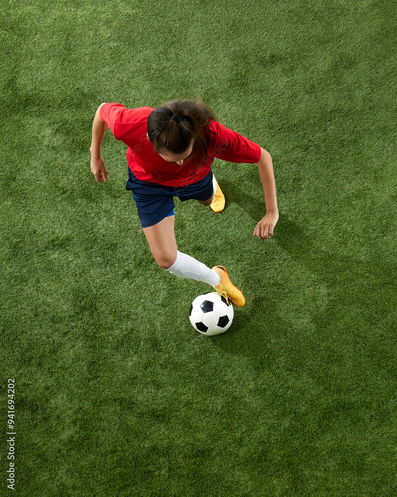 Aerial view of female football athlete training dribbling technique on green lush stadium. Workout for win. Concept of women and sport, team games, movement, victory, action. Ad