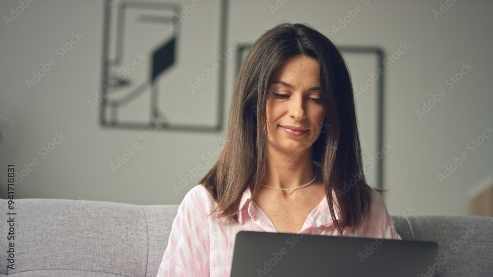 Woman working from home sitting on couch using Woman working from home sitting on couch using