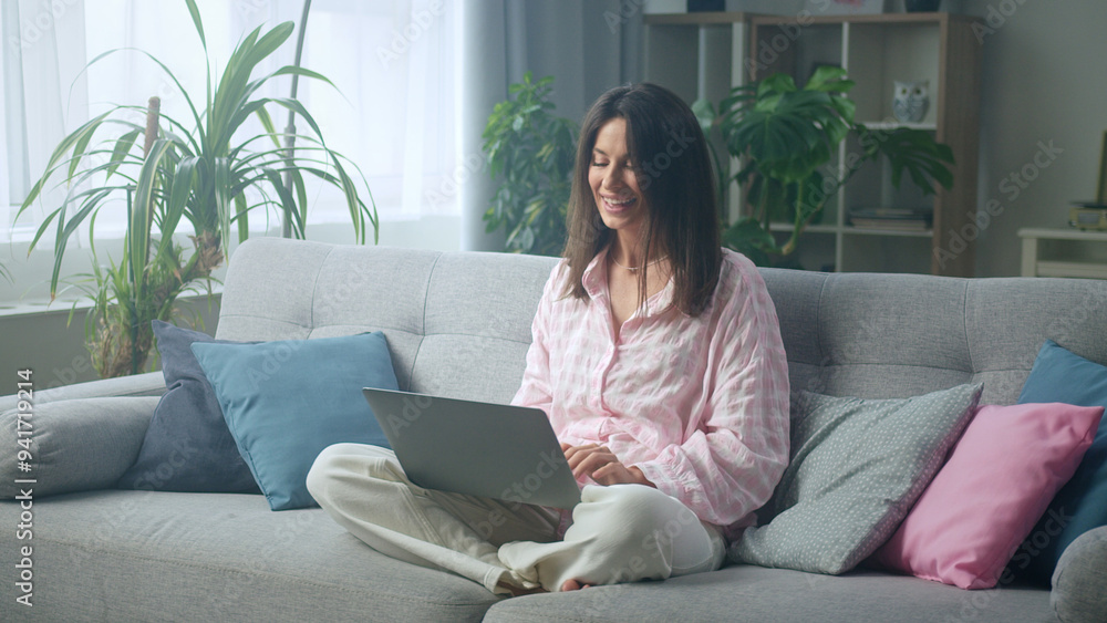 Woman relaxing on couch using laptop at home Woman relaxing on couch using laptop at home