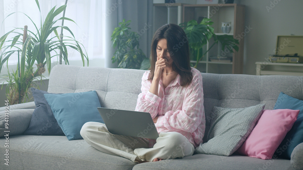 Woman feeling worried while working at home on Woman feeling worried while working at home on