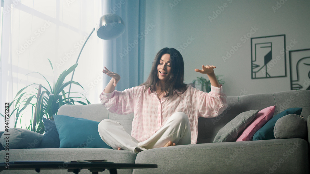 Naklejka premium Beautiful woman is sitting on a sofa and relaxing