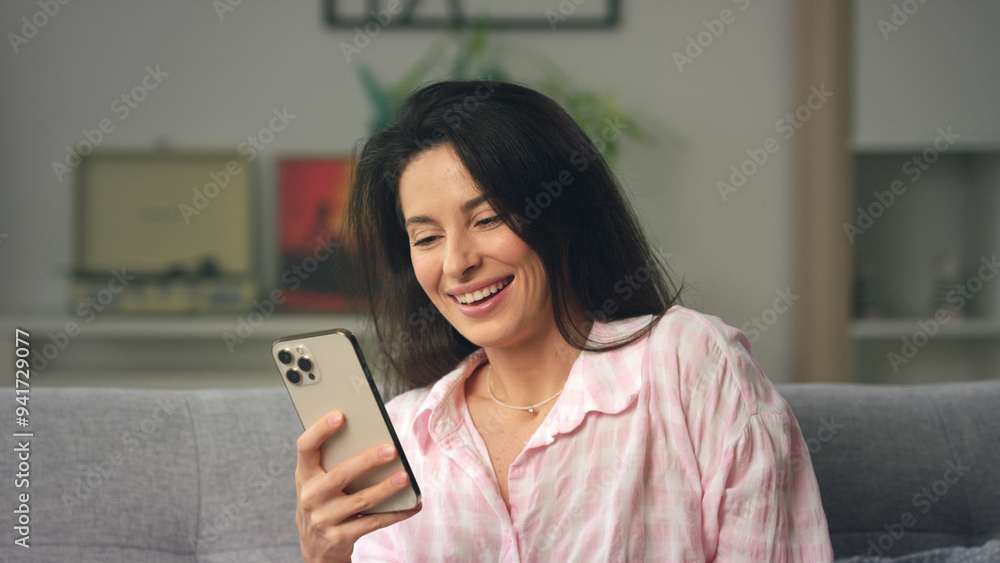 Woman laughing while reading a message on her Woman laughing while reading a message on her