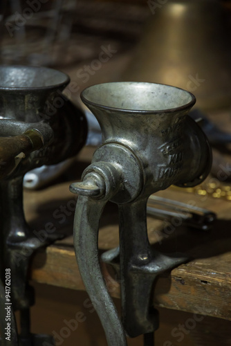 Antique meat grinders attached to a wooden table