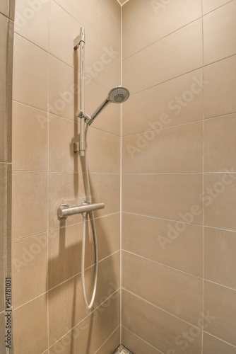 Modern showerhead in a beige tiled bathroom photo